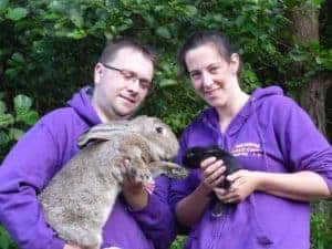 Charity founders holding a giant rabbit and a baby rabbit.